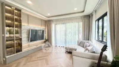 Elegant living room with large windows, modern decor, and cozy seating area.