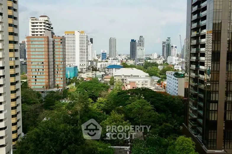 Stunning cityscape view from high-rise apartment showcasing lush greenery and modern architecture.