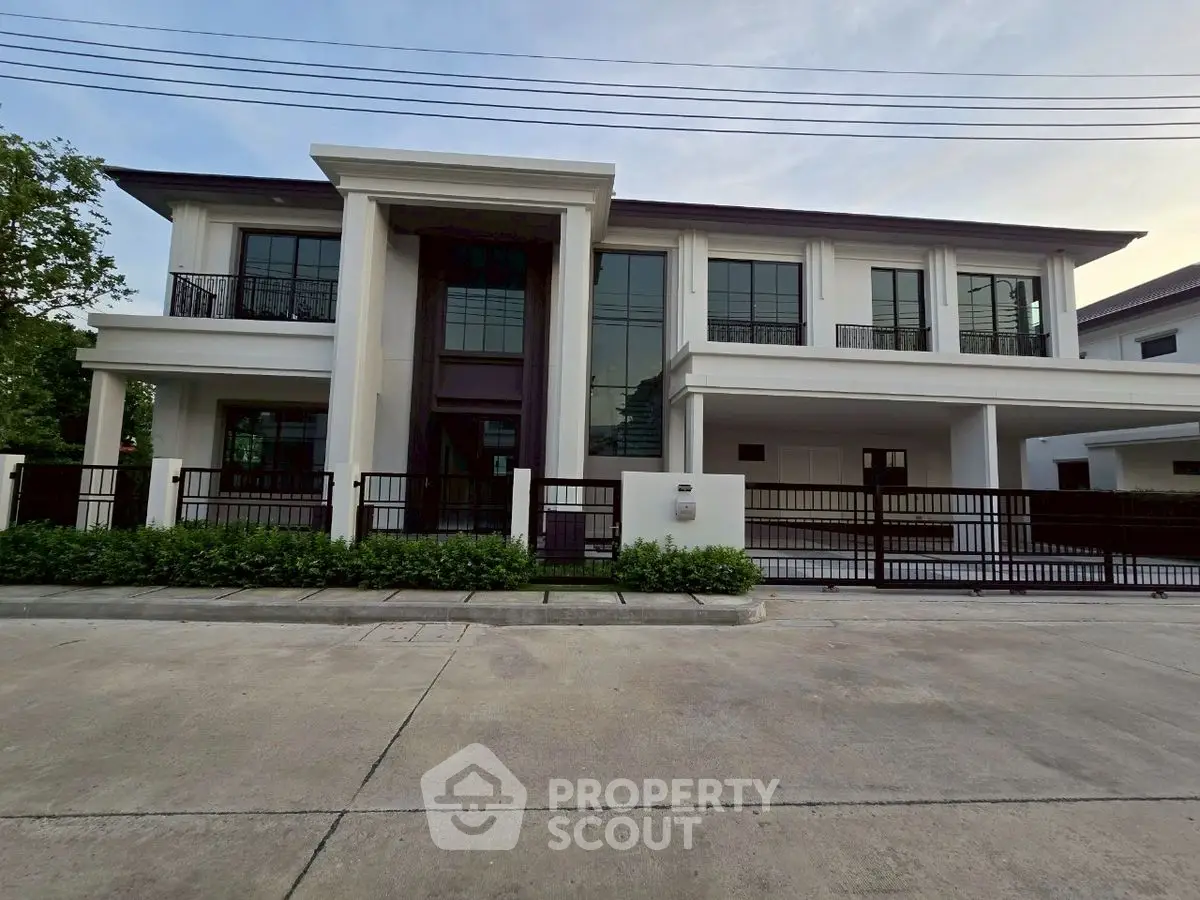 Luxurious modern two-story house with elegant facade and spacious driveway.