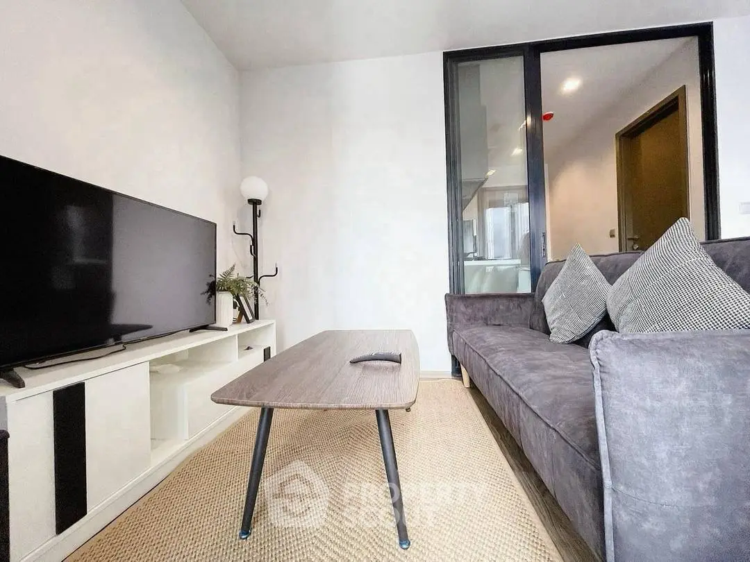 Modern living room with sleek furniture and large TV, perfect for relaxation and entertainment.