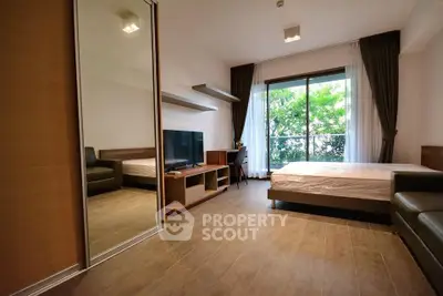 Modern bedroom with large window and sleek furnishings in a stylish apartment.