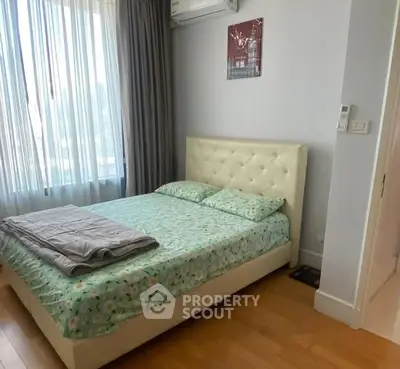 Cozy bedroom with large window and modern decor in a stylish apartment.