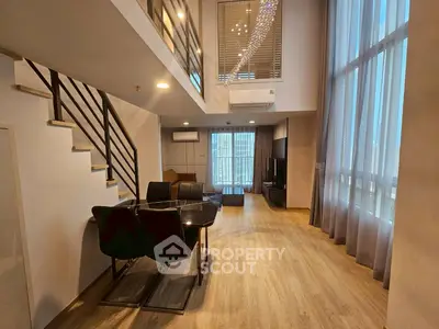 Spacious modern living room with high ceilings and elegant decor in a duplex apartment.