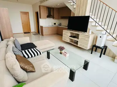 Spacious living room with modern open kitchen and stylish staircase