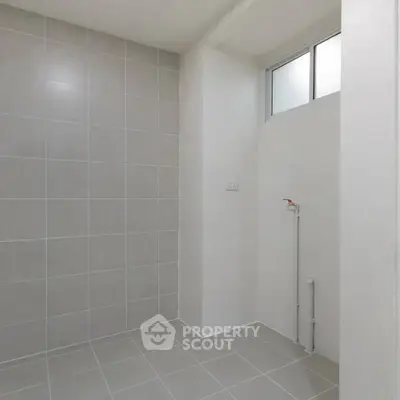 Spacious tiled bathroom with modern fixtures and natural light
