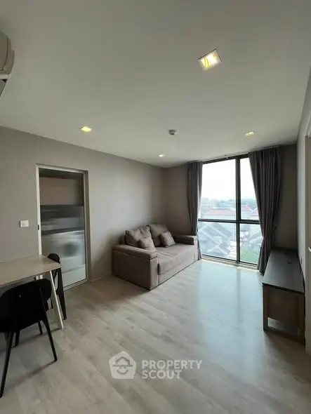 Modern living room with large window and cozy sofa in a stylish apartment.