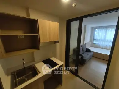 Modern compact kitchen with open layout and adjacent cozy living area