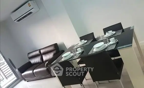 Modern dining area with sleek black furniture and air conditioning