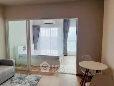Modern apartment with cozy living room and bright bedroom separated by sliding glass doors.
