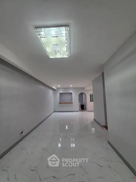 Spacious and modern living room with elegant lighting and marble flooring.