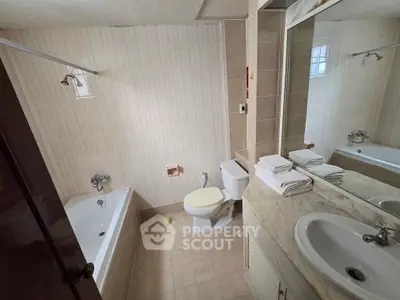 Spacious bathroom with bathtub and modern fixtures, ideal for relaxation.