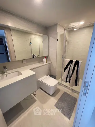 Modern bathroom with sleek design, featuring a glass shower and stylish fixtures.