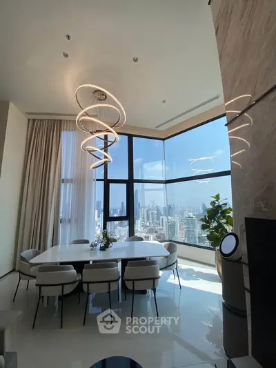 Luxurious dining area with stunning city view and modern lighting in high-rise apartment.