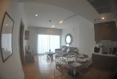 Modern living room with open kitchen, cozy seating, and elegant dining area in a stylish apartment.