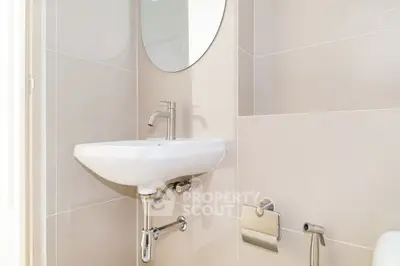 Modern bathroom with sleek sink and round mirror, ideal for contemporary living.
