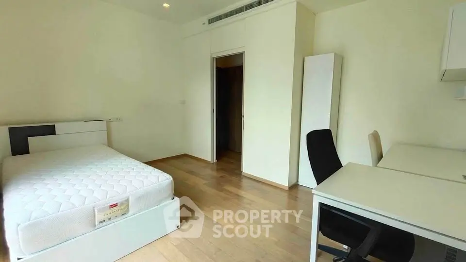 Spacious bedroom with modern furniture and wooden flooring