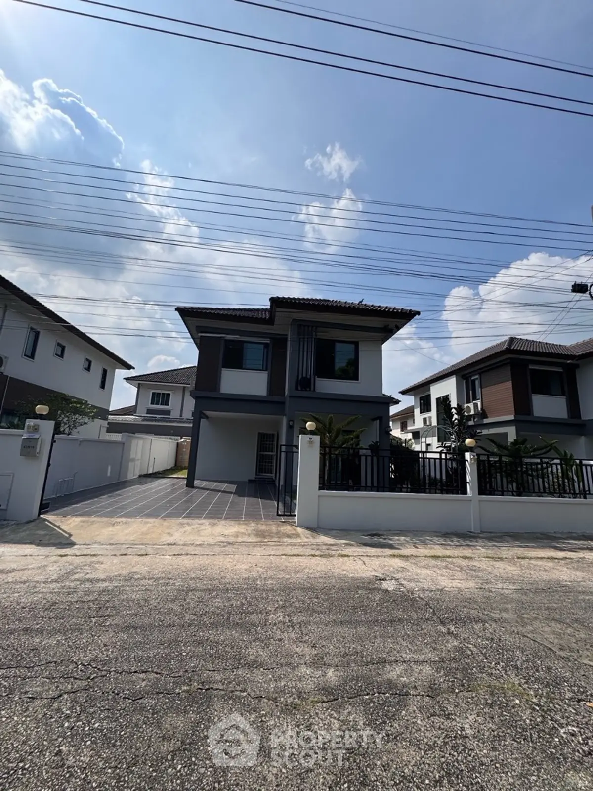 Modern two-story house with driveway and front yard in suburban neighborhood.