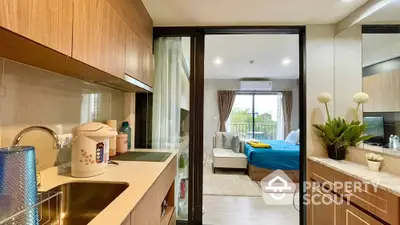 Modern studio apartment with seamless open layout connecting a fully equipped kitchen to a cozy bedroom area, featuring large windows for ample natural light.