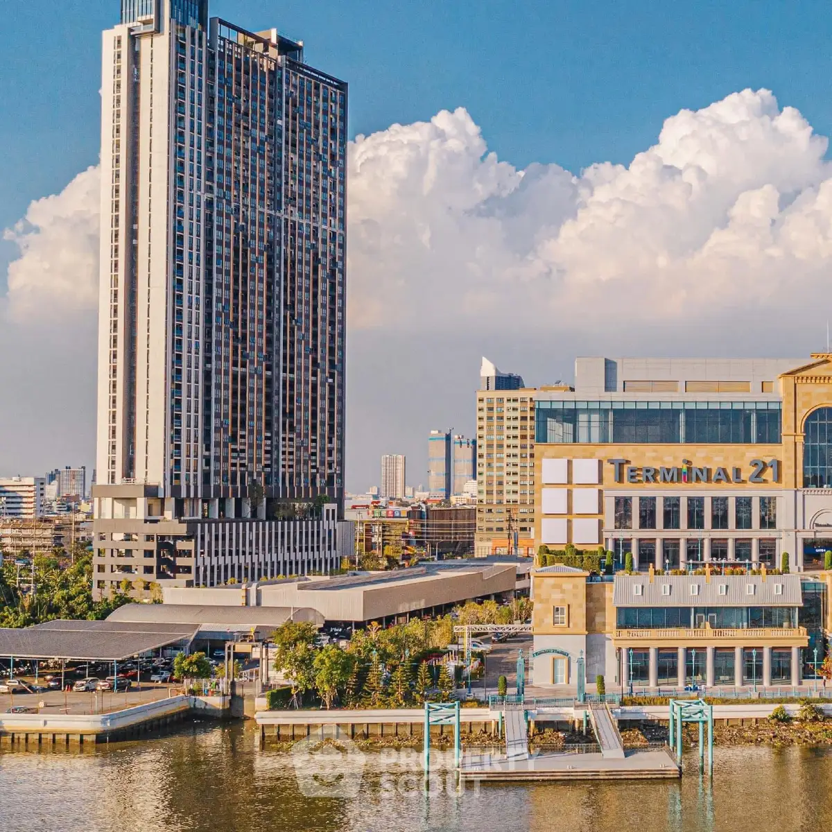 Stunning riverside view of modern high-rise building next to Terminal 21 shopping complex.