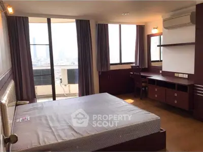 Spacious bedroom with city view, featuring large windows and modern furnishings, ideal for urban living.