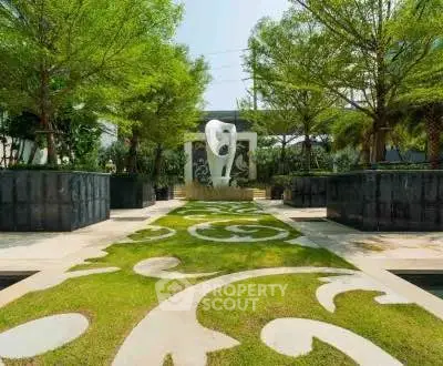 Luxurious garden with artistic sculpture and lush greenery in modern real estate setting.
