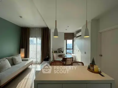 Modern living room with stylish decor and natural light, featuring a cozy seating area and dining space.