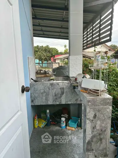 Outdoor kitchen area with marble countertops and storage space