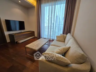 Modern living room with large window and city view, featuring a cozy sofa and sleek TV setup.