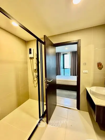 Modern bathroom with shower and view into a cozy bedroom in a stylish apartment.