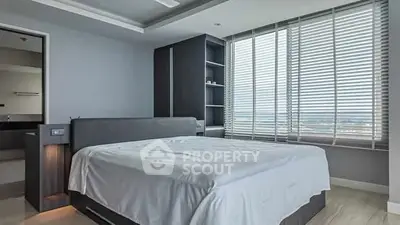 Spacious modern bedroom with large windows and elegant furnishings.