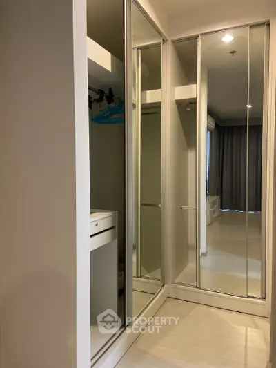 Spacious modern bedroom with mirrored wardrobe and sleek design