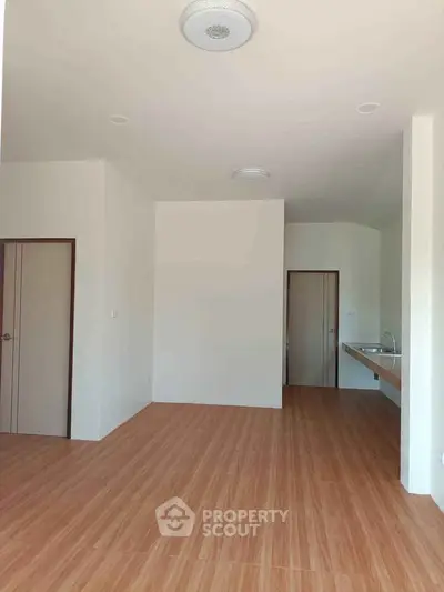 Spacious open-plan living area with wooden flooring and modern fixtures.