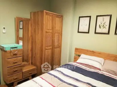 Cozy bedroom with wooden furniture and striped bedding, perfect for a restful retreat.