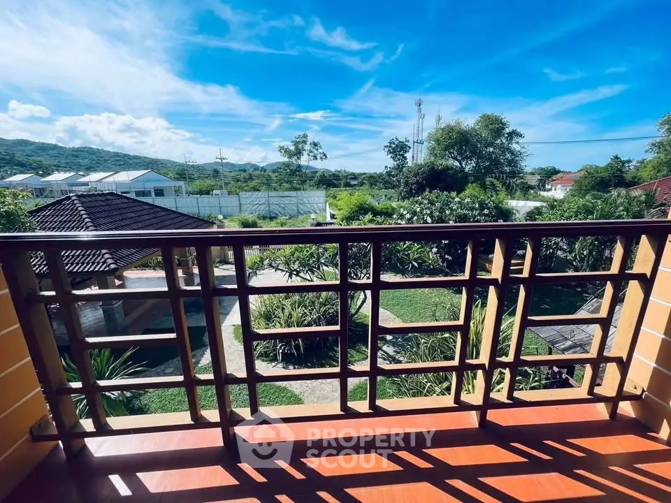 Stunning balcony view with lush greenery and clear blue skies, perfect for relaxation.