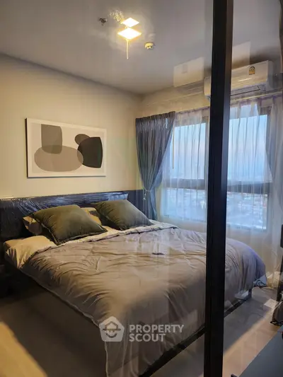 Modern bedroom with large window and stylish decor in a high-rise apartment.