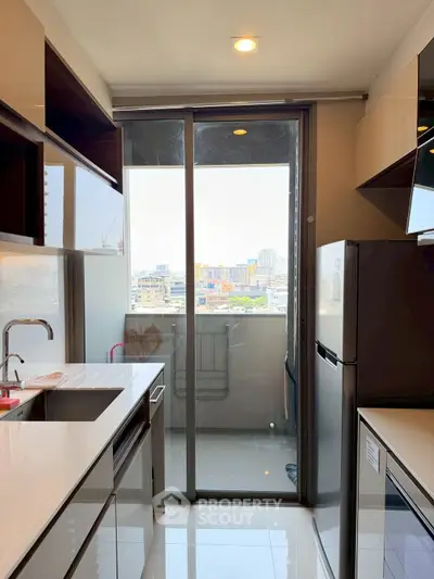 Modern kitchen with sleek appliances and balcony view in urban apartment