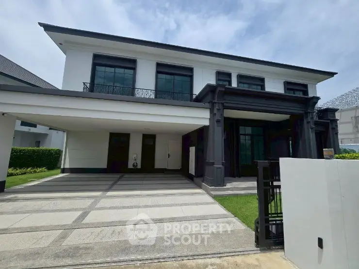 Luxurious modern two-story house with spacious driveway and elegant facade.