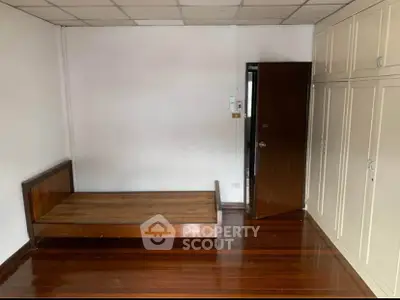 Spacious bedroom with wooden flooring and built-in wardrobe