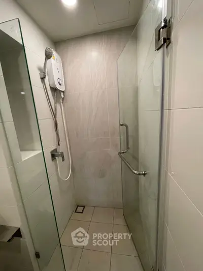 Modern bathroom with glass shower enclosure and wall-mounted water heater.