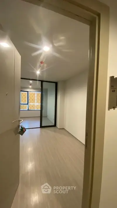Spacious modern apartment entrance with sleek flooring and natural light
