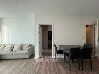 Modern living room with sleek dining area and cozy sofa, featuring elegant wood flooring.