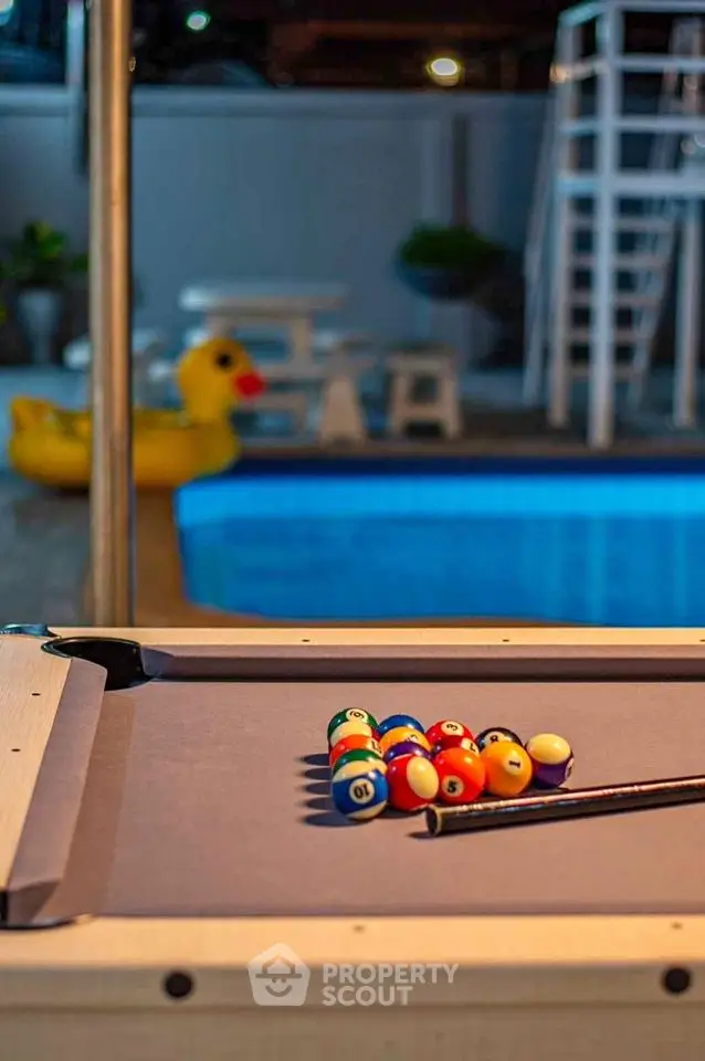 Luxurious poolside area with billiards table and inflatable duck, perfect for entertainment and relaxation.