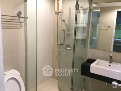 Modern bathroom with glass shower enclosure and sleek fixtures