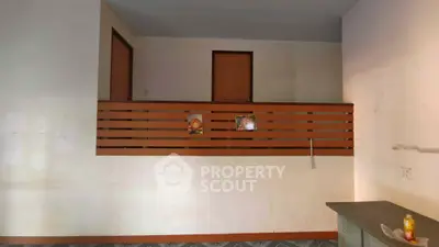 Spacious interior with unique wooden railing and high ceiling, ideal for creative renovation.