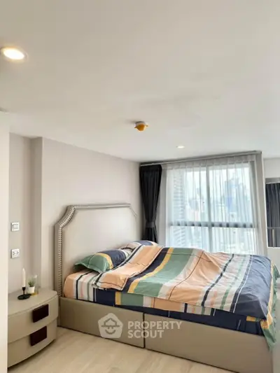 Modern bedroom with large window and stylish decor in high-rise apartment