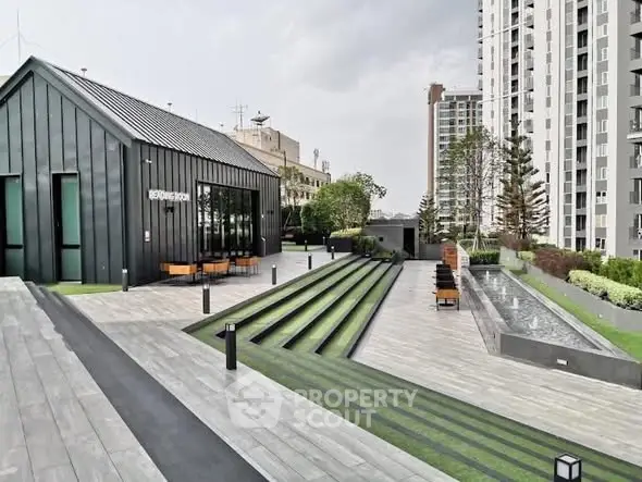 Modern rooftop terrace with sleek design and greenery in urban high-rise setting.