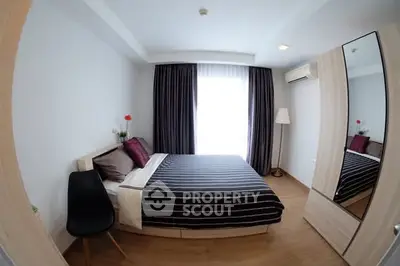 Modern bedroom with stylish decor and ample natural light, featuring a cozy bed and sleek furnishings.