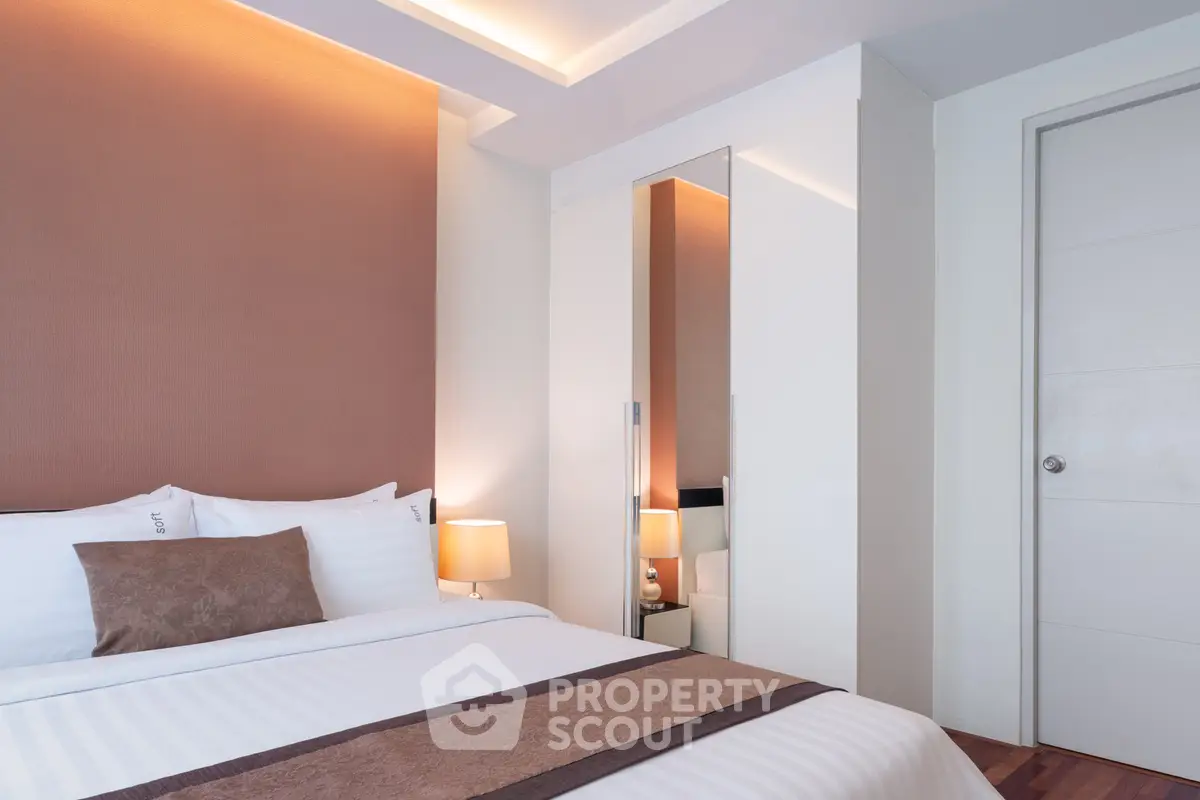 Modern bedroom with elegant design and cozy lighting in a stylish apartment.
