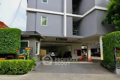 Modern apartment building with covered parking and lush greenery