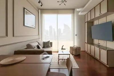 Modern living room with city view, stylish furniture, and large TV, perfect for urban living.